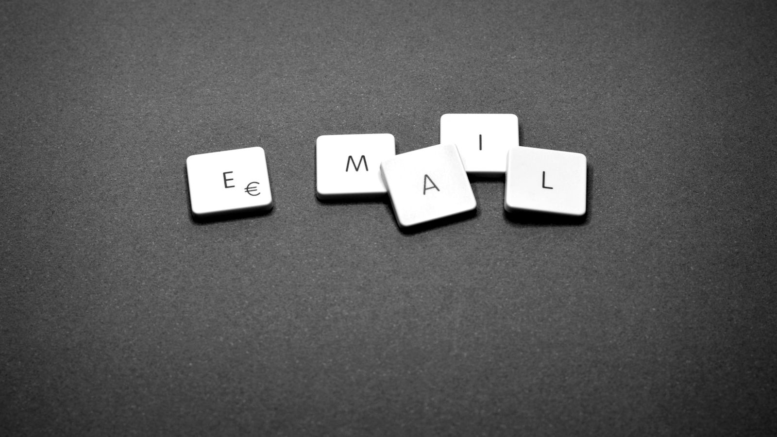 Des lettres en bois formant le mot e-mail, posées sur une table